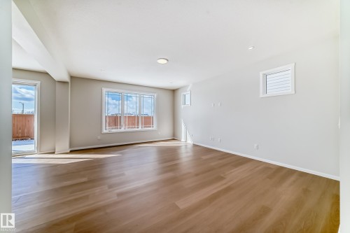 Spacious room featuring light wood flooring, several windows, and recessed lighting - 1516 206 Street Nw, Edmonton, AB - Indoor Photo Showing Other Room