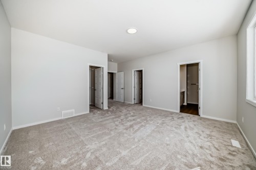Spacious room featuring light-colored carpet flooring, white walls, and a window providing natural light - 1516 206 Street Nw, Edmonton, AB - Indoor Photo Showing Other Room
