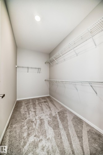 Walk-in closet featuring light gray carpeting, white walls, and wire shelving for storage - 1516 206 Street Nw, Edmonton, AB - Indoor With Storage