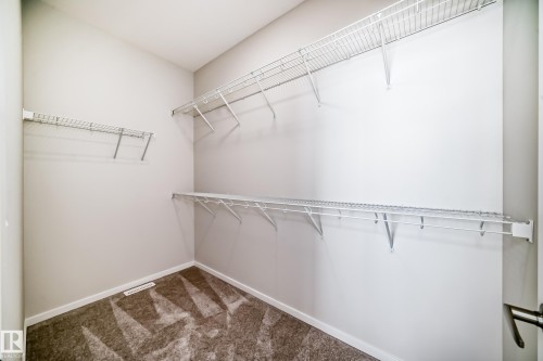Walk-in closet with ample wire shelving and carpeted flooring - 1516 206 Street Nw, Edmonton, AB - Indoor With Storage