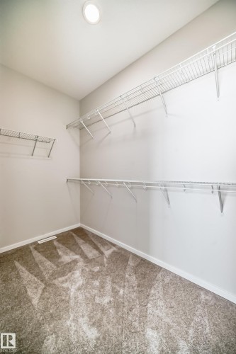 The property features a closet with carpeted flooring, white walls, and wire shelving - 1516 206 Street Nw, Edmonton, AB - Indoor With Storage