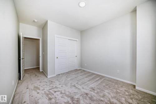 The room features light gray carpeting, neutral-colored walls, and a recessed ceiling light - 1516 206 Street Nw, Edmonton, AB - Indoor Photo Showing Other Room