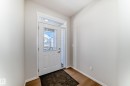 Entryway featuring light hardwood flooring, a white door with clear glass panels, and a transom window above - 1516 206 Street Nw, Edmonton, AB  - Indoor Photo Showing Other Room 