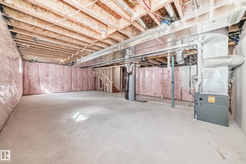 The property features a spacious unfinished basement with a concrete floor, exposed ceiling joists, and insulated walls - 1516 206 Street Nw, Edmonton, AB - Indoor Photo Showing Basement