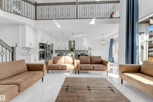 Open-concept living space featuring high ceilings and white polished tile flooring - 1923 19 Avenue, Edmonton, AB - Indoor Photo Showing Living Room