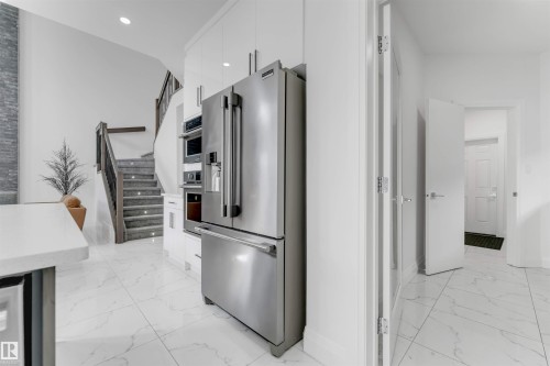 Modern kitchen space featuring stainless steel appliances and white cabinetry - 1923 19 Avenue, Edmonton, AB - Indoor