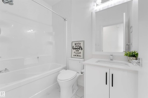 Full bathroom featuring a white vanity with a light-colored countertop, rectangular undermount sink with chrome faucet, and a large wall-mounted mirror - 1923 19 Avenue, Edmonton, AB - Indoor Photo Showing Bathroom