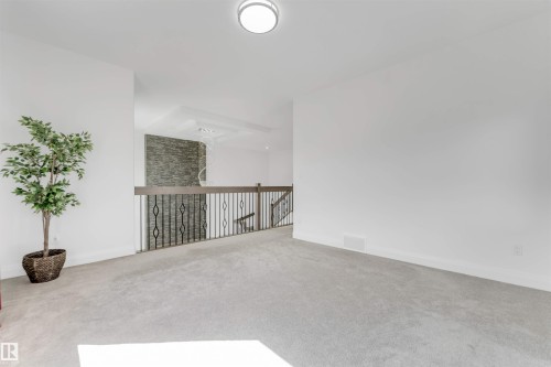 Carpeted landing area featuring a contemporary flush mount ceiling light - 1923 19 Avenue, Edmonton, AB - Indoor Photo Showing Other Room