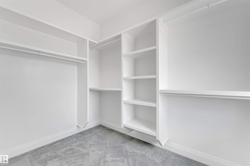 White built-in closet system featuring multiple shelving units and hanging rods - 1923 19 Avenue, Edmonton, AB - Indoor With Storage