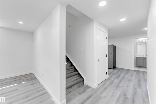 Modern interior featuring light wood-finish flooring, recessed lighting, and a neutral white color palette - 1923 19 Avenue, Edmonton, AB - Indoor Photo Showing Other Room