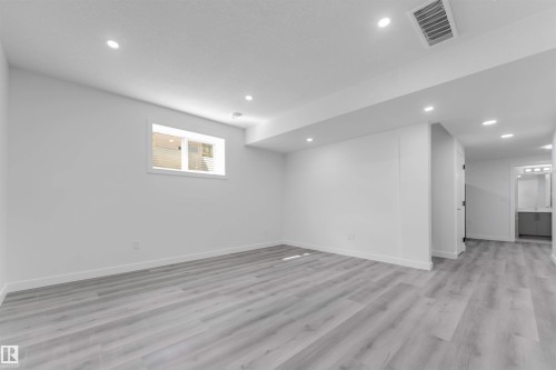 Spacious interior room featuring light wood-finish flooring and recessed ceiling lights - 1923 19 Avenue, Edmonton, AB - Indoor Photo Showing Other Room