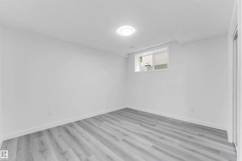 Room featuring light wood-finish flooring, white walls, and a single window - 1923 19 Avenue, Edmonton, AB - Indoor Photo Showing Other Room