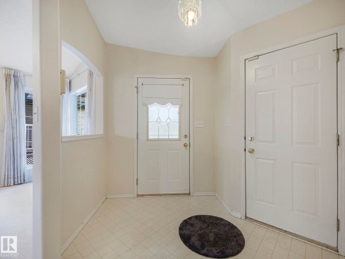 Foyer entry featuring a decorative glass paneled door, a second solid door, and light-toned flooring - 23 9731 174 Street, Edmonton, AB - Indoor Photo Showing Other Room