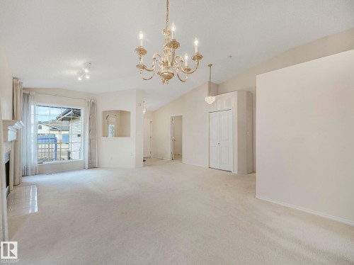 Spacious living & Dining area featuring vaulted ceilings, a fireplace with a tiled hearth, and a large bay window - 23 9731 174 Street, Edmonton, AB - Indoor