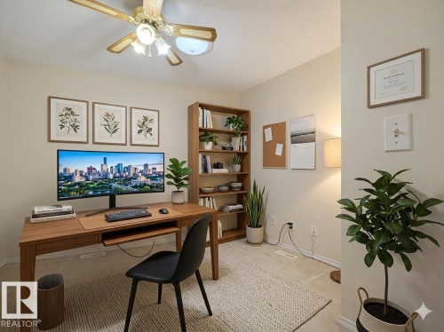 Dedicated office space featuring light-toned wall paint, wood-finish flooring, and a ceiling fan with integrated lighting - 23 9731 174 Street, Edmonton, AB - Indoor Photo Showing Office