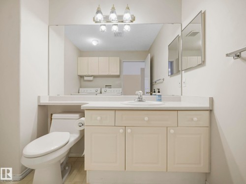 Bathroom vanity with an integrated sink, polished chrome faucet, and ample storage cabinetry - 23 9731 174 Street, Edmonton, AB - Indoor Photo Showing Bathroom