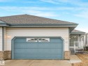 Single-story residence featuring light-colored siding and a blue garage door with decorative windows - 23 9731 174 Street, Edmonton, AB  - Outdoor 