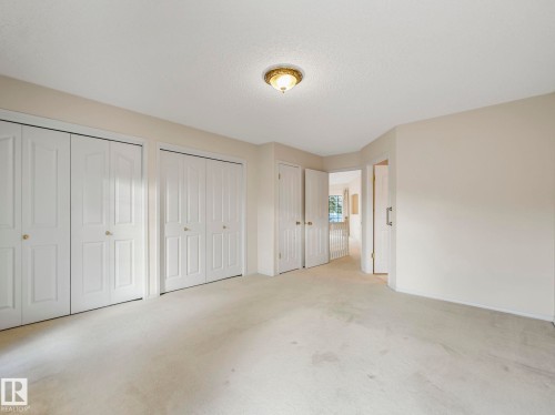 Neutral-toned carpeting throughout the expansive room - 23 9731 174 Street, Edmonton, AB - Indoor Photo Showing Other Room
