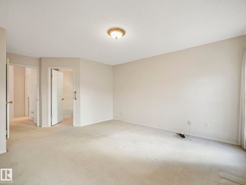 Carpeted room with neutral wall tones and a ceiling-mounted light fixture - 23 9731 174 Street, Edmonton, AB - Indoor Photo Showing Other Room