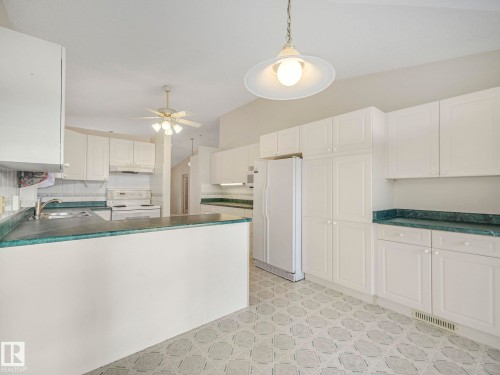 Spacious kitchen with ample white cabinetry and contrasting green countertops - 23 9731 174 Street, Edmonton, AB - Indoor Photo Showing Kitchen