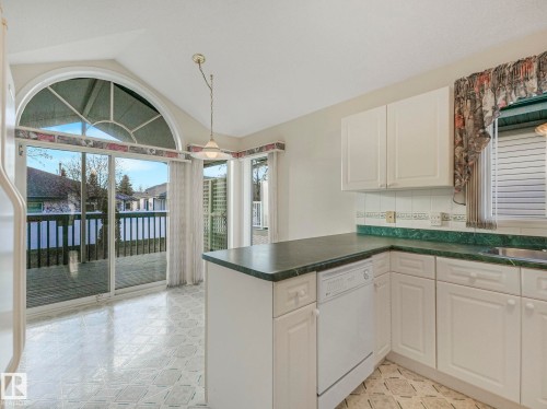 Kitchen featuring white cabinetry, green countertops, and patterned tile flooring - 23 9731 174 Street, Edmonton, AB - Indoor Photo Showing Kitchen