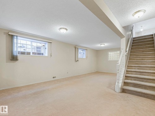 Spacious room featuring neutral carpeting, light-toned walls, and recessed lighting - 23 9731 174 Street, Edmonton, AB - Indoor