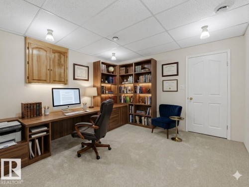Home office featuring extensive built-in cabinetry and shelving with integrated lighting - 23 9731 174 Street, Edmonton, AB - Indoor Photo Showing Office
