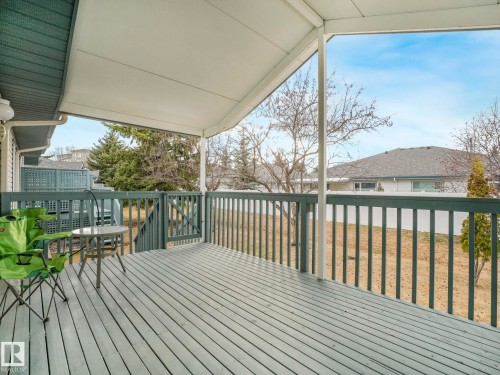 Expansive covered deck featuring wood-finish flooring, a full railing system, and direct access to the outdoor space - 23 9731 174 Street, Edmonton, AB - Outdoor With Deck Patio Veranda With Exterior