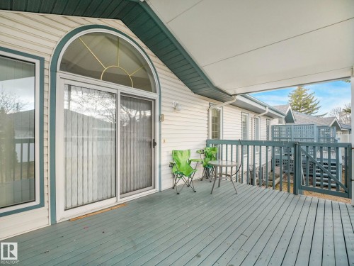 Covered outdoor deck featuring painted wood plank flooring - 23 9731 174 Street, Edmonton, AB - Outdoor With Deck Patio Veranda With Exterior