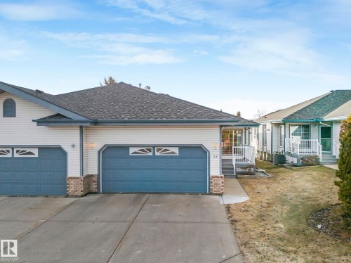 Two-car garage with overhead doors featuring decorative window inserts - 23 9731 174 Street, Edmonton, AB - Outdoor