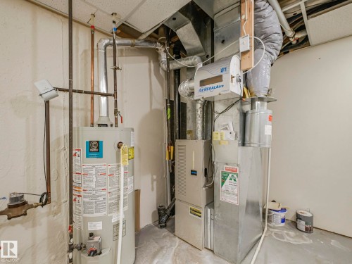 Water heater and furnace with exposed ductwork, drop ceiling, and concrete flooring - 23 9731 174 Street, Edmonton, AB - Indoor Photo Showing Basement