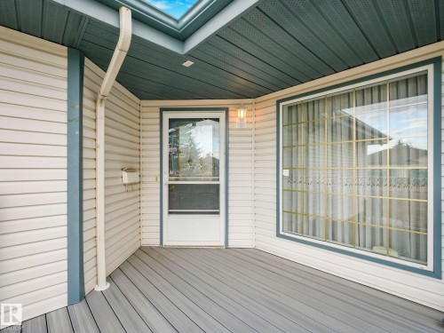 Exterior entryway featuring light-colored siding and a contrasting dark soffit - 23 9731 174 Street, Edmonton, AB - Outdoor With Deck Patio Veranda With Exterior