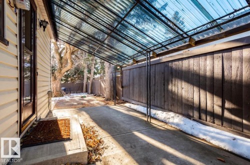 Covered patio featuring a corrugated translucent roof, concrete flooring, and an ornate metal frame - 11681 72 Avenue, Edmonton, AB - Outdoor