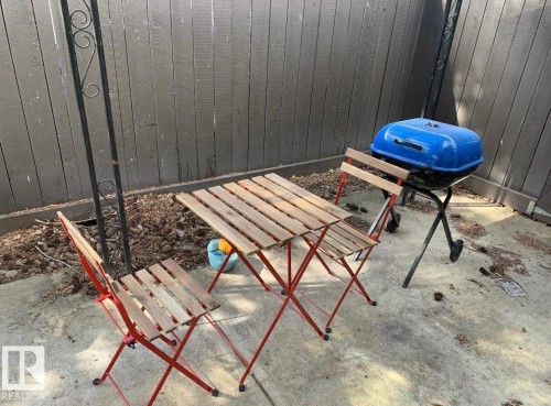 Concrete patio area with a dark-painted privacy fence - 11681 72 Avenue, Edmonton, AB - Outdoor