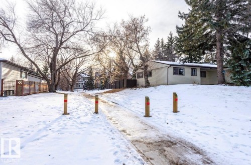 Light-colored siding exterior residence situated on a snow-covered lot - 11681 72 Avenue, Edmonton, AB - Outdoor