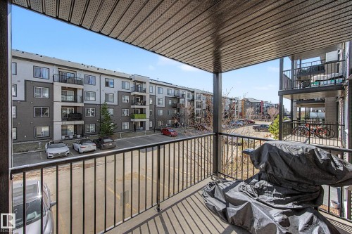 Balcony with a black metal railing and a textured overhead ceiling - 217 394 Windermere Road, Edmonton, AB - Outdoor With Balcony With Exterior