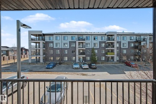 Balcony with black metal railings overlooking a modern residential building featuring a multi-tone facade and individual balconies - 217 394 Windermere Road, Edmonton, AB - Outdoor With Balcony