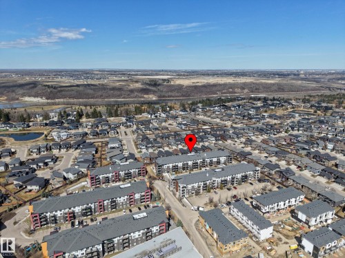 Aerial overview of a residential area featuring multiple multi-story apartment buildings with dark gray roofs and balconies - 217 394 Windermere Road, Edmonton, AB - Outdoor With View