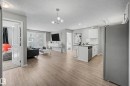 Open-concept living space featuring wood-finish flooring throughout, a modern chandelier, and recessed lighting - 217 394 Windermere Road, Edmonton, AB  - Indoor Photo Showing Kitchen 