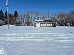 The property includes a two-car garage with white paneled doors and a dark green roof - 
