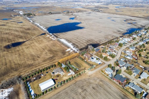 Aerial perspective showcasing expansive agricultural fields bordered by residential development - 2B Discovery Avenue, Rural Sturgeon County, AB 