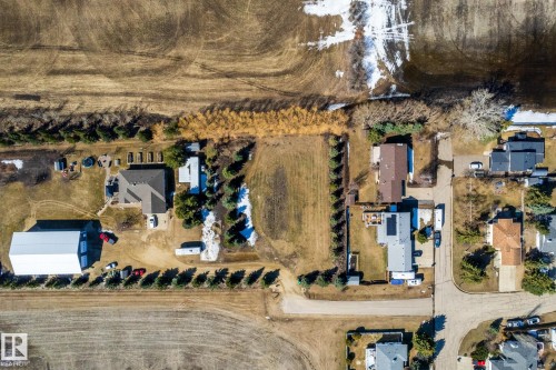 Aerial property overview featuring a main residence with an attached garage, a large detached outbuilding, and significant surrounding land - 2B Discovery Avenue, Rural Sturgeon County, AB 