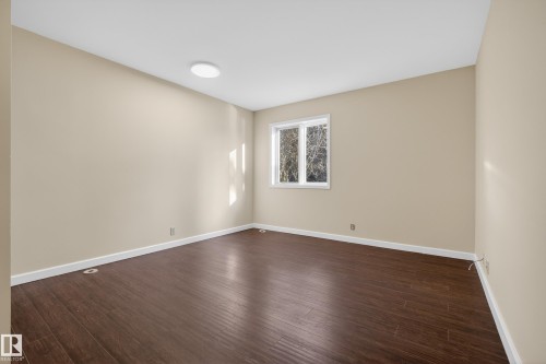 Room featuring dark wood-finish flooring, light neutral-toned walls, and white baseboards - 33 Glen Meadow Crescent, St. Albert, AB - Indoor Photo Showing Other Room