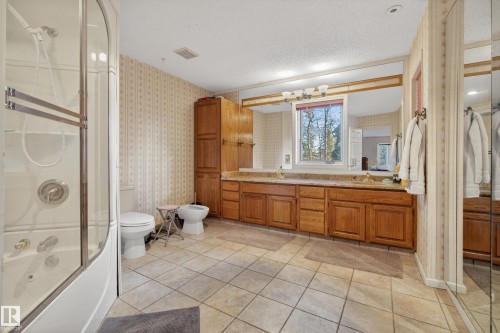 Bathroom featuring a combination shower and jetted tub, dual vanity with a large mirror, and tiled flooring - 33 Glen Meadow Crescent, St. Albert, AB - Indoor Photo Showing Bathroom