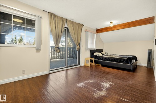 Spacious room with wood-finish flooring, exposed ceiling beam, and neutral wall paint - 33 Glen Meadow Crescent, St. Albert, AB - Indoor Photo Showing Bedroom