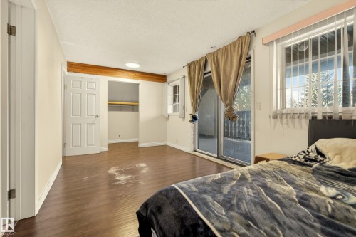 Spacious room featuring wood-finish flooring, a prominent wooden ceiling beam, and a skylight - 33 Glen Meadow Crescent, St. Albert, AB - Indoor