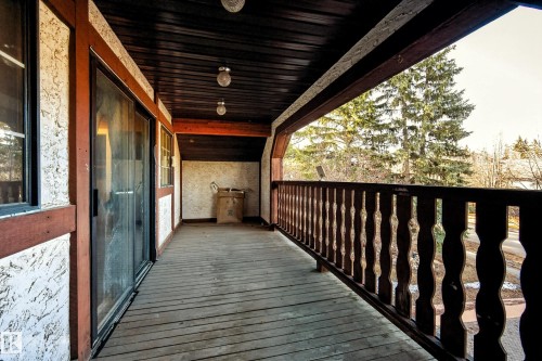 Spacious covered balcony featuring wood-finish flooring, wood-paneled ceiling, and sliding glass door access - 33 Glen Meadow Crescent, St. Albert, AB - Outdoor With Exterior
