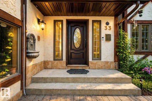 Inviting entrance featuring a dark wood-finish door with an oval glass insert, flanked by vertical sidelight windows - 33 Glen Meadow Crescent, St. Albert, AB - Outdoor With Deck Patio Veranda With Exterior