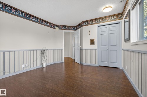 Spacious room featuring wood-finish flooring, white walls, and a textured ceiling - 33 Glen Meadow Crescent, St. Albert, AB - Indoor Photo Showing Other Room