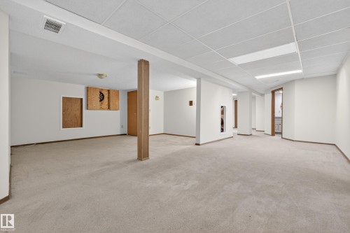Spacious lower level featuring light-toned carpeting, white walls, and a dropped acoustic ceiling - 33 Glen Meadow Crescent, St. Albert, AB - Indoor